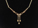 un collier plaqué or avec une longue chaîne et des pendentifs en forme de gouttes