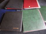 several different colored notebooks sitting on top of a black table