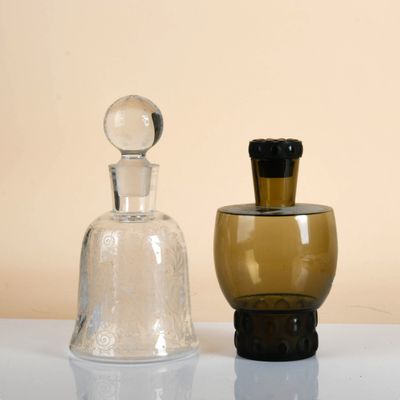 two glass bottles sitting next to each other on a table