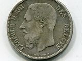 une vieille pièce de monnaie avec un visage d'homme sur une surface blanche