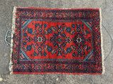 un tapis rouge bordé de bleu posé à même le sol