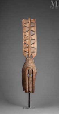 une image représentant une sculpture en bois posée sur un socle, sur fond gris