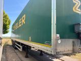 un semi-remorque vert garé sur le bord de la route