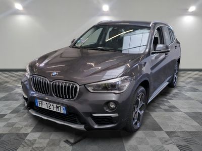 La BMW X1 est garée dans un showroom dont le sol est en damier.