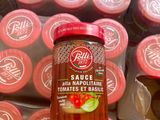 un bocal de sauce posé sur une pile de tomates