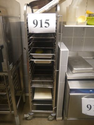 several trays of food are stacked on a rack in a kitchen