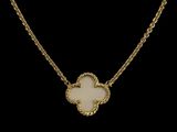 un collier en or orné d'une fleur blanche sur fond noir