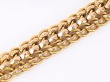 a close up of a gold chain bracelet on a white surface