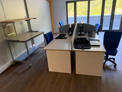 un bureau avec deux ordinateurs et deux chaises dans la pièce