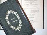 an old book with a wreath on it sitting on a table