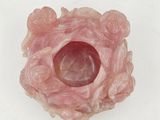 a pink object with a hole in it on a white surface
