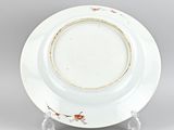 a white plate with a gold rim on a clear stand
