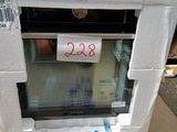 un micro-ondes blanc posé sur un carton sur lequel est accrochée une étiquette de prix