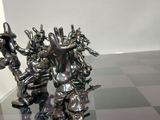 a silver statue of a man and a woman on a chess board