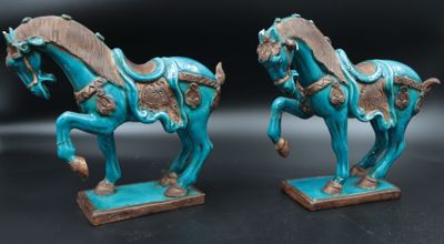 paire de figurines de chevaux émaillées de turquoise, posées sur des socles, sur fond noir