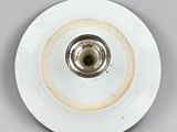 underside view of a white porcelain plate with a silver rim