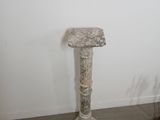 a marble pedestal in a corner of a room