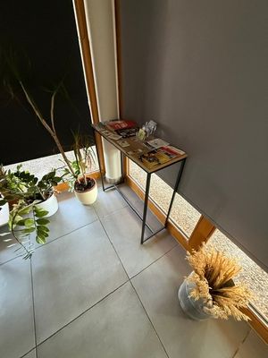 une petite table sur laquelle se trouve une plante, dans une pièce