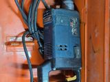 a drill in a cabinet with a cord attached to it
