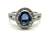 gros plan d'une bague avec une pierre bleue entourée de diamants blancs
