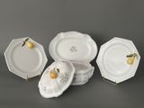 four pieces of porcelain dishes with fruit on them on a table