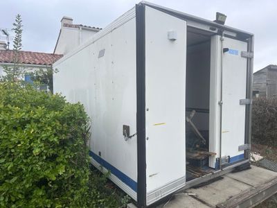 une photo représentant des toilettes portables blanches dans un jardin