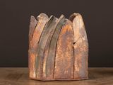 a brown vase that is sitting on a wooden table