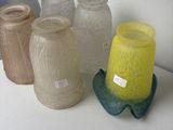 many different colored vases sitting on a white table