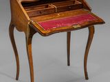 an antique writing desk with a red leather top