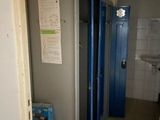 doorway view of a bathroom with blue lockers and a white sink