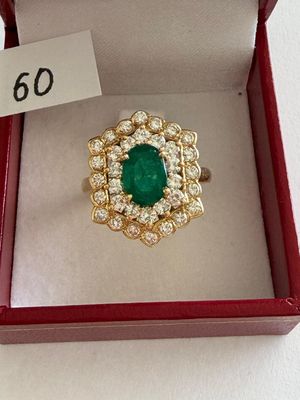 an emerald and diamond ring in a red box with a price tag