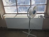 a fan sitting in front of a window in a room