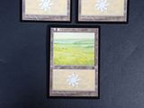 three cards are sitting on a table with a black background