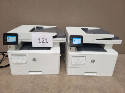 two hp laser printers are sitting side by side on a table