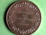 an old bronze medal on a green surface with a green background