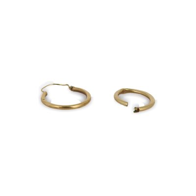 une paire de boucles d'oreilles en or sur fond blanc