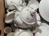 a box full of white and gold china dishes and cups