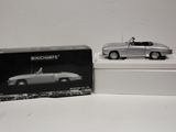 une boîte contenant une maquette argentée d'une voiture de sport et une boîte avec une photo en noir et blanc d'une voiture de sport