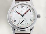 une montre blanche avec une trotteuse rouge et un bracelet marron