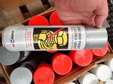 a person holding a spray can of paint in a box