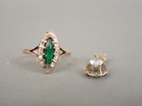 un gros plan d'une bague sertie d'une pierre verte et d'un diamant blanc