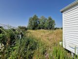 une petite maison blanche au milieu d'un champ
