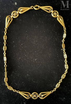 a gold bracelet with intricate design on a black surface