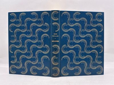 un vieux livre à la couverture bleue ornée de volutes argentées