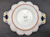 a white bowl with a blue and yellow design on it
