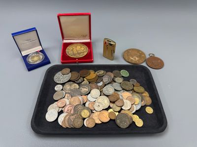 un plateau rempli de pièces de monnaie et une médaille posés sur une table