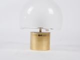 a white and gold table lamp with a glass dome on a gold base