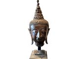 la tête d'une statue de Bouddha posée sur un socle en marbre
