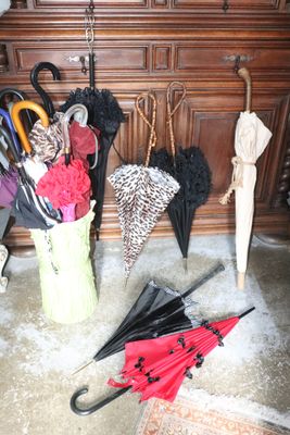 many umbrellas that are sitting in a bucket on the floor