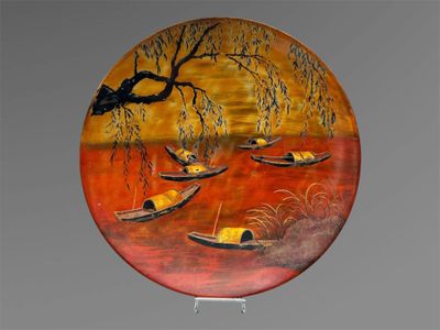une assiette ornée d'une peinture représentant des bateaux flottant sur l'eau